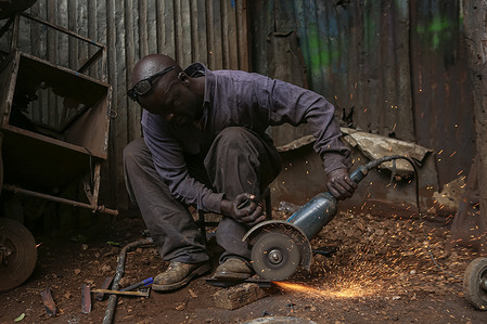 A Kenyan welding artisan (commonly known as Jua kali man) at his workshop along Pumwani road during a normal day at the Gikomba market in Nairobi.