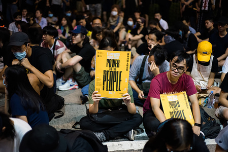 A protester holds up a "Power to the People" placard during the rally.
Demonstrators organized a peaceful rally aimed at building momentum going into the 10th weekend of protests. Rally organizers gave various speeches and displayed videos of various members of British Parliament showing support for Hong Kong's anti-protesters. The demands made by protesters related to the withdrawal of the extradition bill have yet to be resolved by the government.