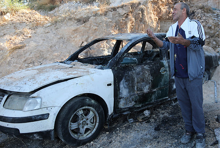 A Palestinian man inspects a burned-out car after an attack by Jewish settlers on Palestinian homes, vehicles and property in the village of Beit Ammar. Israeli forces raided and searched Palestinian homes as part of a large-scale search and arrest operation that included the Ras al-Ain area, the Old City, and the Askar refugee camp. Palestinians reported that five Palestinians were arrested during the operation.