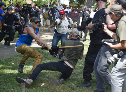A member of the white supremacist and a protester are seen fighting.
White supremacists gathered at Emancipation Park in Charlottesville, Virginia for the Unite the Right Rally. Virginia's Governor McAuliffe declared a State of Emergency as violence erupted before the rally could begin between counter protesters and white supremacists around Emancipation Park. Later in the afternoon White supremacists James Alexander Fields Jr. drove his silver dodge charger into a crowd of counter protesters killing Heather Heyer and injuring multiple others.