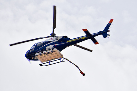 A water bomber helicopter is seen in the airspace. A water bomber helicopter circles between the sea and a hillside fire in Marseille.