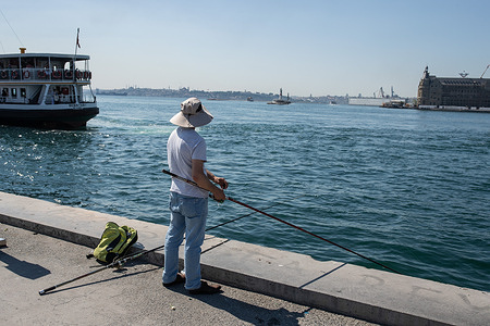 A man is seen fishing at the Kadikoy pier as the hot weather takes its toll on Istanbul.