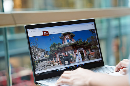 In this photo illustration, A woman browses The Official Tourism Website of Vietnam on her laptop.
