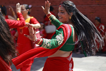 A woman dances during the Teej festival at Pashupatinath Temple. Married and unmarried Hindu women observe fasting during the festival. Married women traditionally abstain from food and water while praying for the longevity, peace, and prosperity of their husbands and families, while unmarried women fast in the hope of being blessed with good husbands.