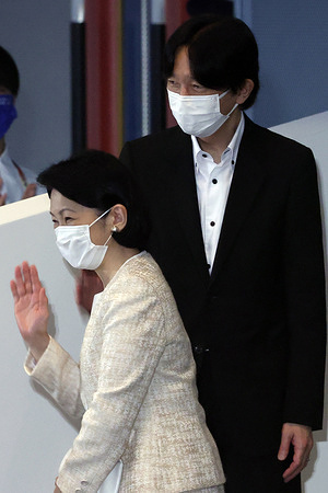Japanese Crown Prince Fumihito and Crown Princess Kiko (L), wearing face masks, attend an event.