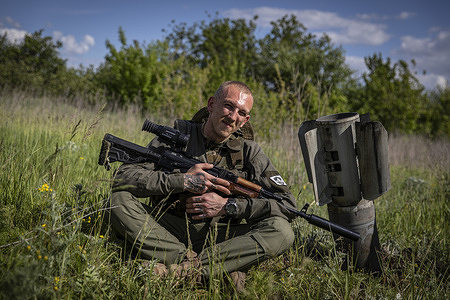 A Ukrainian soldier sits beside a unexploded Russian missile on the outskirt of the separatist region of Donetsk (Donbas). Ukraine's Donetsk (Donbas) region is under heavy attack from the Russian troops. The Russian invasion of Ukraine started on February 24, the war has killed thousands civilians and soldiers.