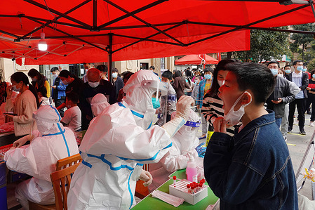 A health worker wearing a Personal Protective Equipment (PPE) performs nucleic acid testing on a community resident in Changzhou. As of March 16, there were 253,944 covid-19 cases in China, including 233,096 in Hong Kong and 193 in Beijing.