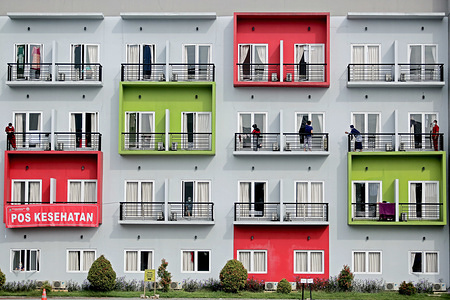 Covid-19 patients sunbathe on the balconies of their rooms at the quarantine house in Tangerang regency.Indonesian President, Joko Widodo has instructed the local government to prepare the New Normal procedures, which will allow people to return to their activities by maintaining strict health protocols amid the new positive cases of Covid-19 that continue to increase.