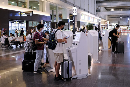 People wearing face masks as a preventive measure against the spread of covid-19 seen at the departure lobby for domestic flights at Tokyo's Haneda Airport in Tokyo.