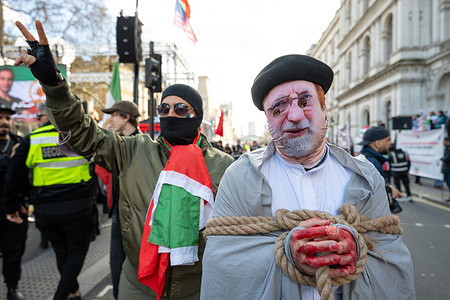 Protesters depicting a scene were the Iranian Mullah has been arrested. Members of the Iranian diaspora gathered outside Downing Street in London for a pro Shah demonstration calling for the overthrow of the Islamic Republic and the restoration of the monarchy in Iran. Protesters waved pre-1979 Iranian flags and displayed images of Shah Pahlavi as they voiced support for regime change, echoing wider international demonstrations against the Iranian authorities. Speakers urged world leaders and the UK government to increase pressure on Tehran and back democratic transition, as part of a broader global movement opposing the current regime.