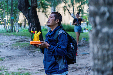 A man says a prayer before sending his Krathong afloat at Benjasiri Park during the Loy Krathong festival in Bangkok. People gather at Benjasiri Park in Bangkok to celebrate the Thai festival Loy Krathong, which takes place on the 12th month of the Thai Lunar calendar on the evening of the full moon.