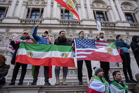 Protesters hold flags while they stand on the wall during the demonstration outside Downing Street in London. Thousands of Iranian royalists protested outside Downing Street in London, UK. Protesters want to show their support to the anti-government protesters in Iran. Demonstrators would like to have the Supreme Leader of Iran, Ayatollah Ali Khamenei and his regime replaced by the Crown Prince of Iran, Reza Pahlavi who lives in exile at the United States.