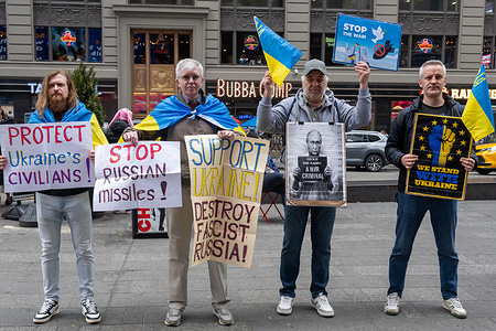 Four man with signs and Ukrainian flags rally in support of Ukraine in Times Square
