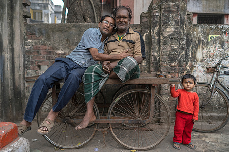 Men sitting on a cart with a chid seen in Kolkata.
Kolkata is the capital of West Bengal state in India, It was the capital under British rule.