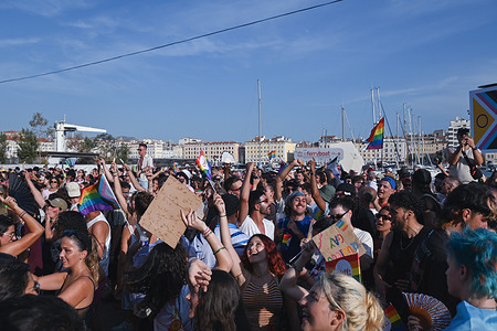 Participants walk on the streets of Marseille brandishing placards and rainbow flags during the pride parade. The Marseille Pride March is celebrated in Marseille with nearly 25,000 participants.