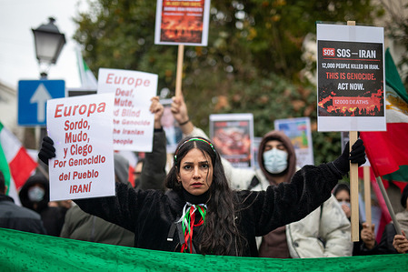 A protester carries banners. during a protest outside the Iranian embassy in Madrid. The demonstrators demanded an end to the violence and repression by the Islamic Republic regime during the protests across Iran.