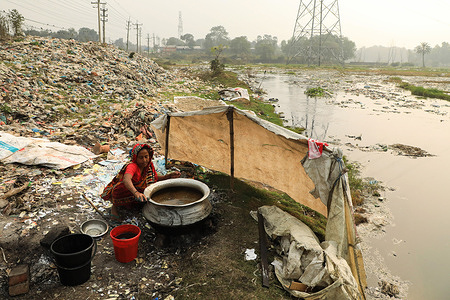 A woman is working in a field polluted with plastic in Gazipur.