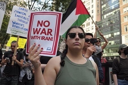 Demonstrators in front of the New York Public Library hold placards during a rally protesting war against Iran. Demonstrators rallied in Manhattan opposing the Israel Defense Forces' airstrikes on Iran. Protesters also condemned the possibility of the United States joining Israel in the war against Iran. Furthermore, protesters criticized the IDF’s military operations in Gaza. The rally occurred as Israel and Iran have been exchanging missile strikes against one another for the past six days. According to American officials, Iran is preparing to attack U.S. military bases in the Middle East if the U.S. joins Israel’s war against Iran.