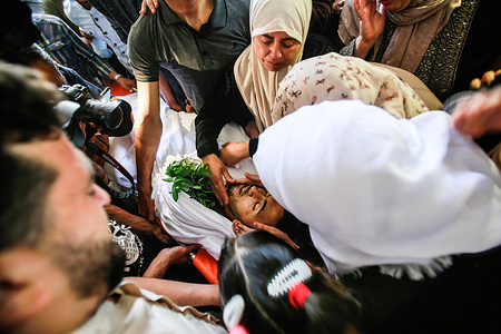 (EDITORS NOTE ; Image depicts death)Relatives of Palestinian Mahmoud Shtawi (19), mourn during his funeral in Gaza after he was killed in an Israeli airstrike. Deafening airstrikes and rocket fire once more shook Gaza overnight and early today amid an international diplomatic push to broker a ceasefire after more than a week of bloodshed.