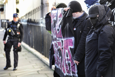 An armed policeman stands on guard as antifa protesters hold a banner saying ‘Free Maja’ as they protest in solidarity with the imprisoned activist on the steps of the Hungarian Embassy in London. A group of anti fascist protesters demonstrated outside the Hungarian Embassy in support of left wing German activist Maja T. Maja a member of proscribed group Antifa Ost was found guilty of attacking those commemorating the Neo-Nazi ‘Day of Honour’ in Budapest and was jailed for eight years.