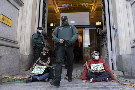 Two activists wearing facemasks are seen glued in the entrance of Ministry of Agriculture while carrying placards during the demonstration.
During the third international rebellion, The Extinction Rebellion movement blocked the entrance of the Ministry of Agriculture this morning to claim the protection of biodiversity in Madrid.