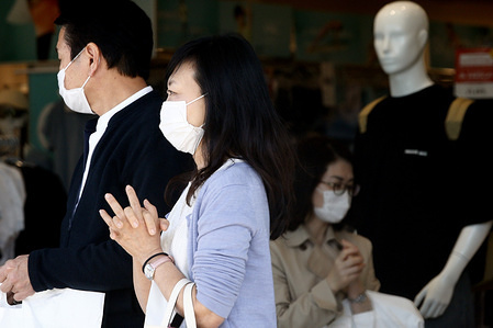 People wait at a bus stop while wearing face masks as a preventive measure during the Coronavirus (COVID-19) crisis.
The Japan government is taking a cautious approach to the possibility of extending the COVID-19 state of emergency for a considerable amount of time as public frustration simmers over business suspensions and restrictions on going out. The emergency declaration is currently set to remain in place until May 6, the last day of the country’s Golden Week holiday period from late this month.