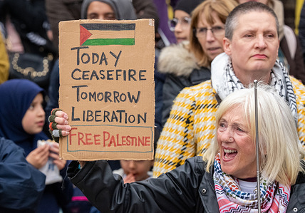 A protester holds a placard saying 'Today Ceasefire . Tomorrow Liberation. Free Palestine' during the rally. Despite the ceasefire in the Gaza conflict protests continued in Manchester. Hundreds of protesters gathered at Piccadilly gardens before marching through the city centre. More than twenty counter protesters, many with cameras for vlogging and live streaming, walked in front of the protest shouting pro Israel and anti Palestinian slogans.