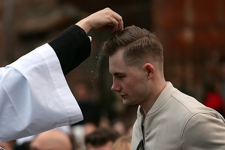 A priest imparts ashes on the head of a boy on Ash Wednesday during Lent in Rome.