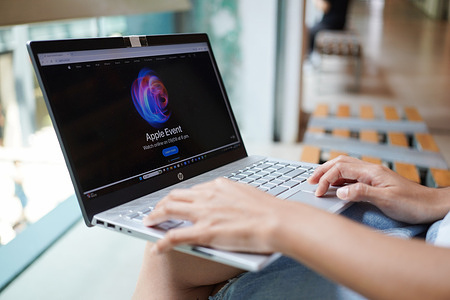 In this photo illustration, A woman browses the Apple website on her laptop.