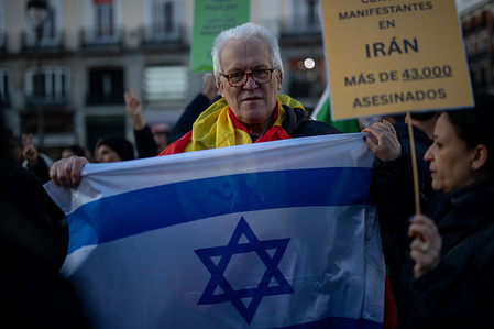 A protester carries an Israeli flag during a demonstration. A demonstration was held by Iranian residents in Madrid's Puerta del Sol to demand an end to the violence and repression by the Islamic Republic regime in Iran.