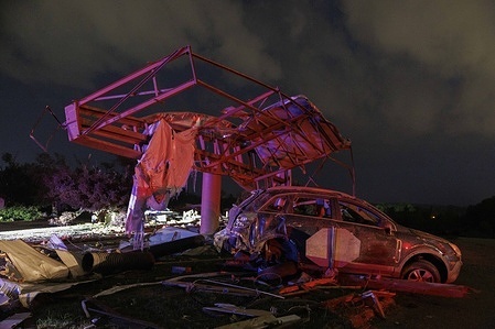 A billboard is seen twisted and a car mangled on South Walnut after the tornado. Several tornadoes hit Greene and Monroe counties in south central Indiana leaving a path of destruction.