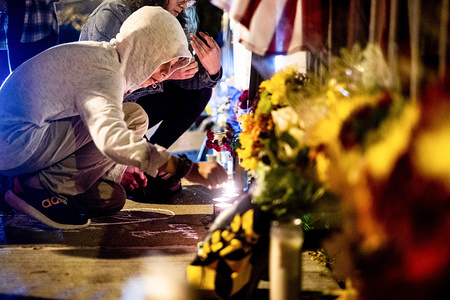 A child light memorial candles in front of the Tree of Life synagogue.
One year after the shooting at the Tree of Life synagogue in Squirrel Hill, many come back to the synagogue to pay their respects.