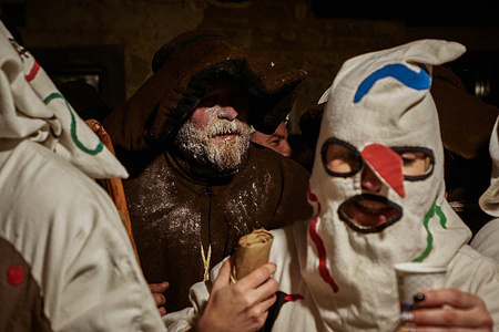 Saint Anthony and a botarga drink anise during the celebration of the medieval Santatona rite that is celebrated on the occasion of the feast of San Antonio.