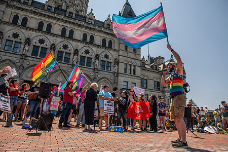 LGBTQ community members seen holding flags and placards during a rally at the capitol building. LGBTQ members and supporters rallied at the capitol building to protest the administration's policies citing a lack of healthcare, recognition and rights for their community. The protesters said these policies are affecting millions of LGBTQ+ individuals across the country.