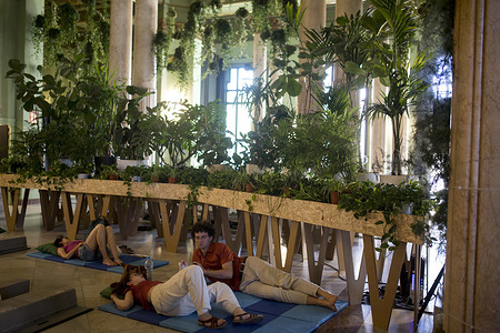 People lie on mats on the floor, during the opening day of the Summer 2025 climate shelter installed at the Círculo de Bellas Artes in downtown Madrid. The Círculo de Bellas Artes uses the Ballroom as a climate shelter, with more than 300 plants and giant hammocks to provide free protection to citizens from high urban temperatures during the summer.