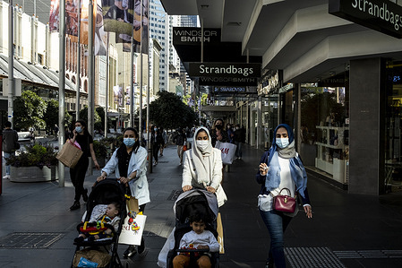 Women wearing face masks as a preventive measure walk past Bourke Street mall.
Melburnians enjoy the first weekend of shopping and nice weather after the Covid-19 restrictions were eased.