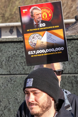 A protester holds a placard during the demonstration. Protesters from Stand up to Racism and other anti racism groups gathered on Sir Matt Busby way at Old Trafford to call for the removal of Sir Jim Ratcliffe from Manchester United football club following his recent comments on migrants to the UK. :Protesters carried placards calling for his removal and outlined the tax paid by migrants in contrast to Ratcliffe's tax payments.
