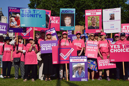 Protesters hold placards in support of the Assisted Dying Bill during the demonstration in Parliament Square. The bill will allow adults who are terminally ill to receive assistance to end their own life, and is currently being debated and voted on by members of parliament.