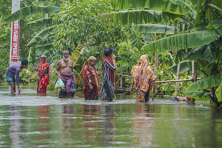 People walk through flood water at Sreenagar in Munshiganj near Dhaka.
One third of Bangladesh is under water after some of the heaviest rains in a decade and more than 3 million people had been affected with homes and roads in villages flooded, Flood Forecasting and Warning Centre (FFWC) officials have said. The flood situation in 20 northern and central districts due to the rise in the water level of the main rivers, including the Brahmaputra, Jamuna, Padma, Teesta and Dharla.