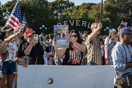A woman holds a sign with details of the event as people gather for a vigil and rally for conservative political activist Charlie Kirk in Beverly Hills. The 31-year-old Kirk was shot and killed while addressing a large crowd at Utah Valley University in the town of Orem on September 10.