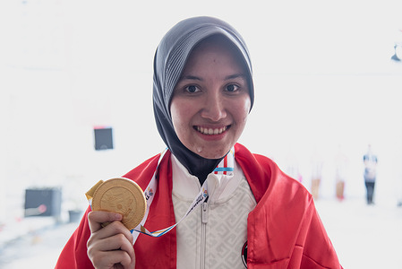Dewi Laila Mubarokha from Indonesia poses with a gold medal during Women 10m Air Rifle Individual final round at SAT shooting range.