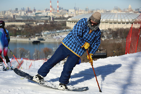 Skiers and snowboarders in costumes seen during the Winter Sports Festival at the Sparrow Hills Ski Complex. People celebrate the end of Winter Sports Season 2026 during a carnival at Ski Complex at the Vorobyovy Gory (Sparrow Hills) with panoramic view to the Moscow International Business Center, Moscow River and Luzhniki Stadium.