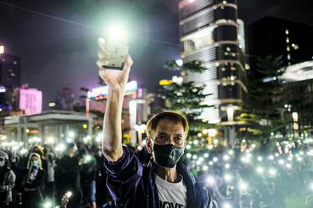 A man holds up his smartphone light during the rally.
Memorial rally at Tamar Park in Hong Kong to mourn the death of a 22 years old university student, Alex Chow Tsz Lok who died from a serious brain injury during a fall on November 4th as police skirmished with demonstrators last weekend. He was left in critical condition and died after suffering a cardiac arrest.
during a protest in the Central district Hong Kong. A "Blossom Everywhere" action was organized by the protestors to paralyze traffic and vandalize things across Hong Kong and in its third consecutive days and have sparked some of the worst violence in five months of unrest.