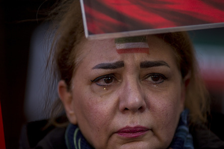 A protester cries as she holds a placard during a demonstration in front of the United States Embassy in Madrid. Iranian community in Madrid stage a demonstration demanding an end to the violence and repression by the Islamic Republic regime across Iran.