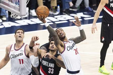 Los Angeles Clippers' John Collins (20) goes to the basket against the Portland Trail Blazers during an NBA basketball game, in Inglewood