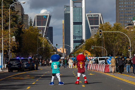 A couple of extras pose on the Paseo de la Castellana during the pre-game coverage of the NFL game played at the Santiago Bernabéu Stadium between Miami Dolphins and Washington Commanders.