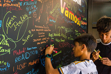 Real Madrid fans sign the visitors' wall at the Pepsi / Lays area. Fans of Spanish Champions League winners, Real Madrid, and Italian UEFA Cup winners, Atalanta, gathered in Kahla Square in Warsaw, beside the Vistula River, for the UEFA Super Cup fan festival. In anticipation of the match the following day, visitors queue to take photos with the trophy and participate in several football-related games and activities. The UEFA Super Cup takes place at PGE Narodowy in Warsaw on 14th August 2024 and is contested by the winners of the Champions League and the UEFA Cup winners.