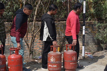 People queue with empty LPG cylinders outside a distribution center of Nepal Gas Industries, as supply concerns rise amid the ongoing U.S.–Israeli conflict with Iran.