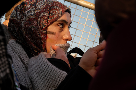 A protester is seen with her face painted with the Palestinian flag during the march in solidarity with Palestine. On the first morning of the year, thousands of people gathered on the Galata Bridge in Istanbul and held a march in support of Palestine.