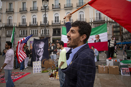 A member of the Iranian community in Madrid chants while holding an Iranian flag during a celebration at Puerta del Sol. Iranians residing in Madrid celebrated Nowruz, the Persian New Year, while also expressing their support for the military intervention launched by the United States and Israel against Iran.